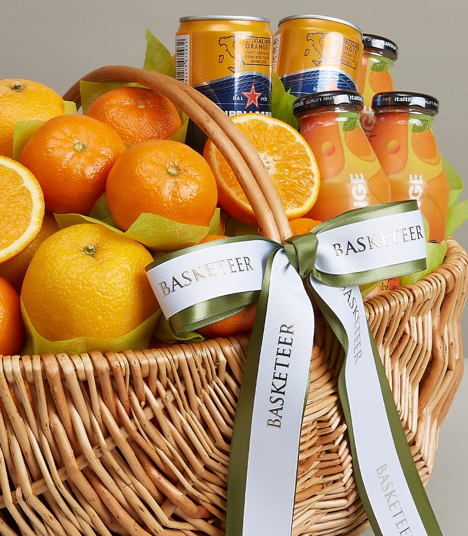 Orange Extravaganza wicker hamper with fresh oranges, citrus beverages, and orange juice in luxury gift basket