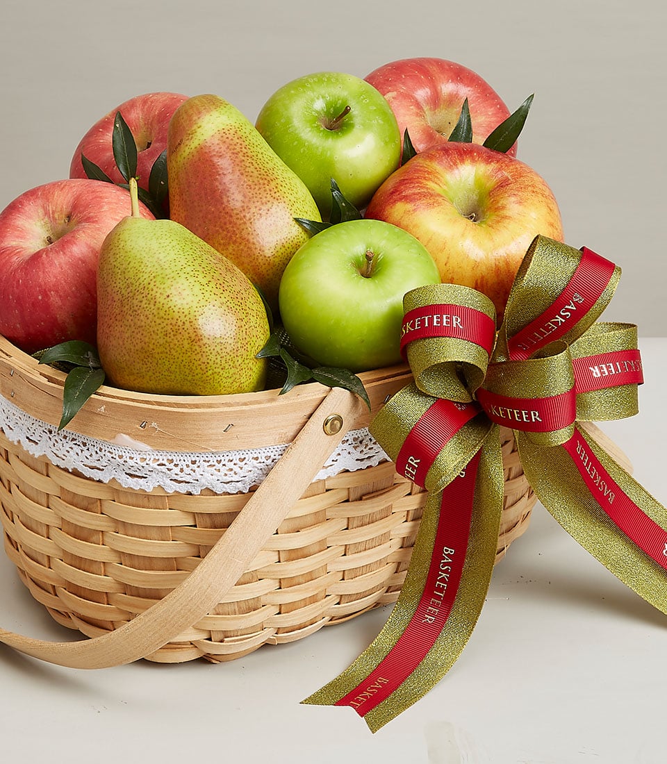 Light woven wood fruit basket with red and green apples, pears, and gold-red ribbon bow