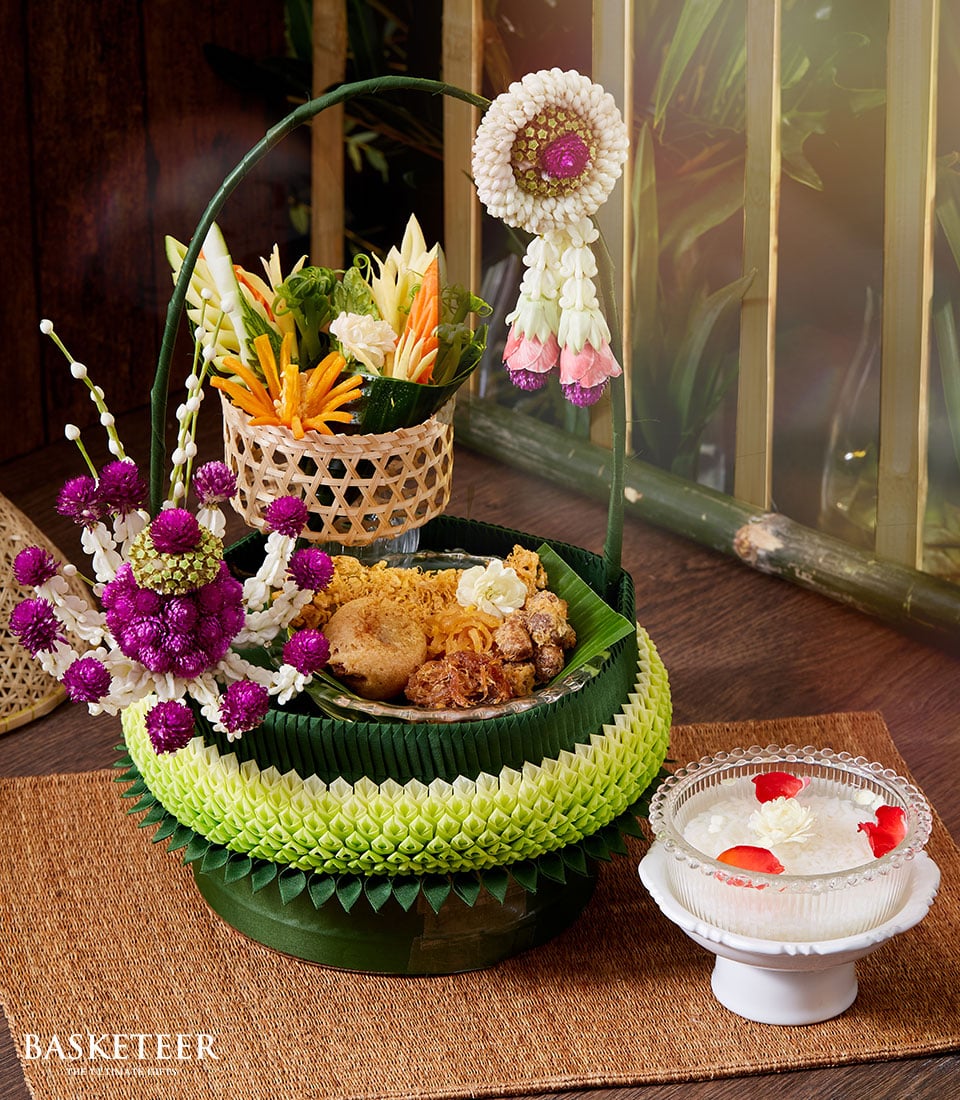Thai Songkran gift basket with banana leaf design, fried delicacies, jasmine flower, and phuang malai garland, plus white