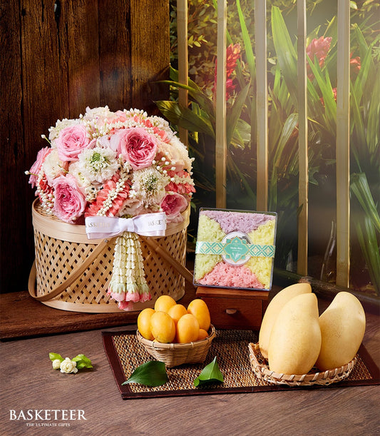 Pink and white rose bouquet with Thai garland, mango sticky rice set, and fresh mangoes in woven baskets for Thai New Year