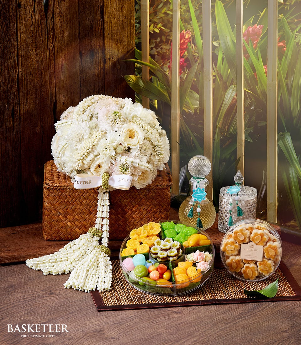 Luxury Thai New Year gift set with white roses, jasmine garland, scented water, and assorted Thai desserts
