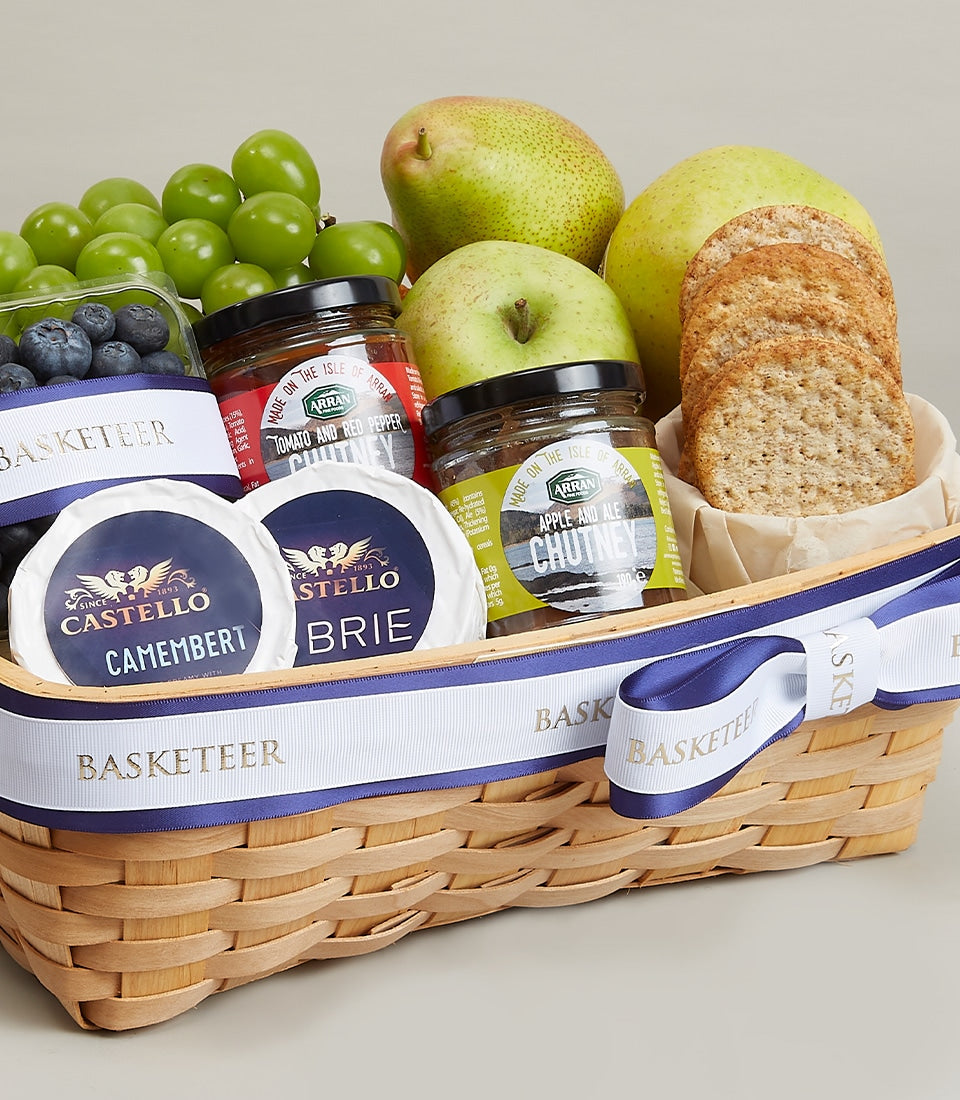 Woven wood gift basket with fresh fruits, artisan cheeses, chutneys, and gourmet crackers