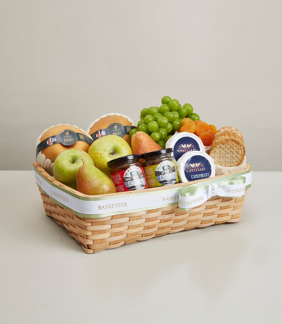 Premium wicker gift basket with fresh pears, apples, grapes, artisan cheeses, chutneys, and crackers