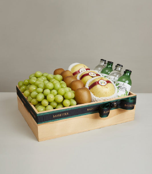 Premium wooden gift box with green grapes, pears, kiwis, and artisan mocktail beverages, tied with dark green ribbon