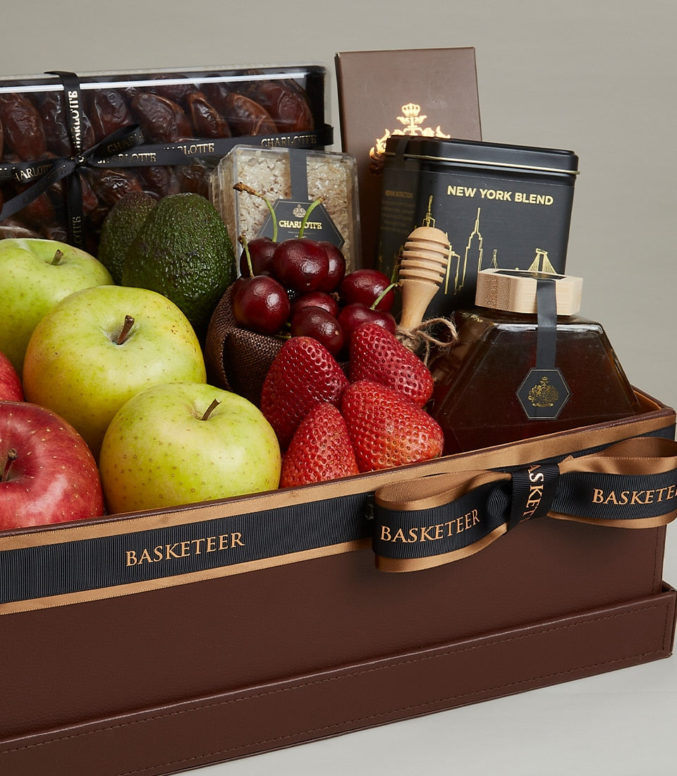 Deluxe leather gift box with fresh apples, avocados, strawberries, cherries, premium honey, gourmet treats, and New York