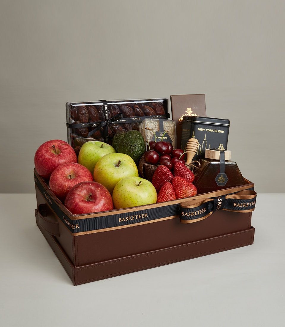 Luxury gourmet fruit and treats gift basket with fresh apples, cherries, strawberries, dates, honey, and premium pantry