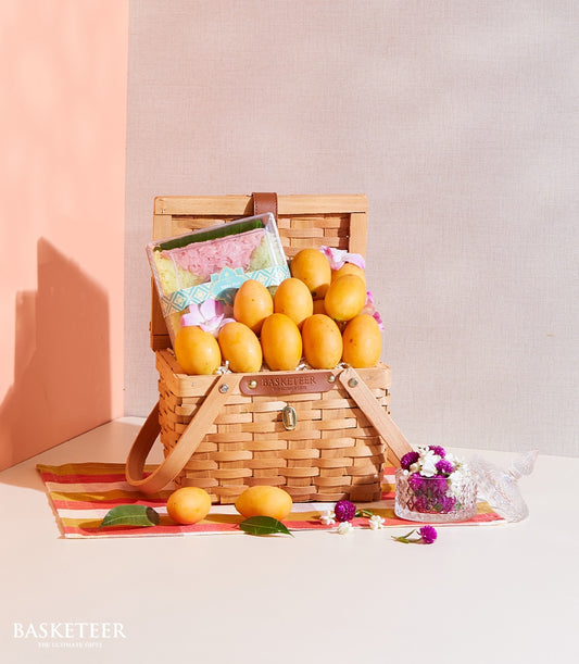 Woven picnic basket with fresh yellow mangoes and layered sticky rice dessert, Thai tropical fruit gift hamper