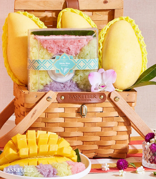 Luxury mango sticky rice gift basket with ripe Thai mangoes, colorful sticky rice, and coconut sauce in woven wicker