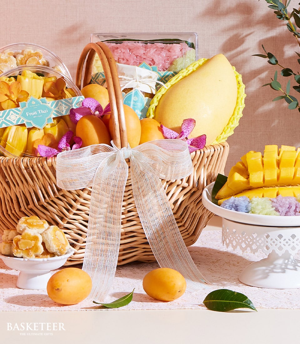 Thai tropical fruits and golden desserts curated in a premium wicker gift basket with fresh mango and sticky rice