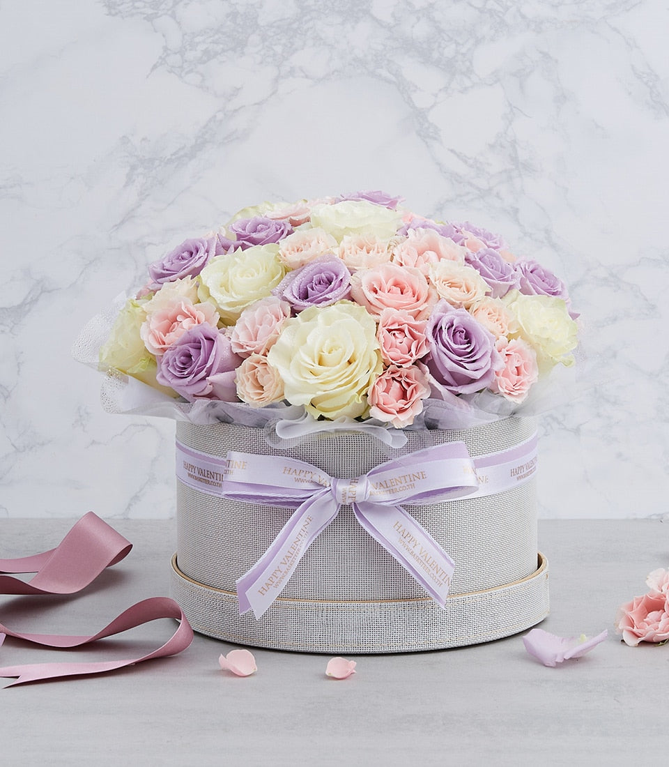 Pastel lavender and pink rose dome arrangement in grey round box with purple ribbon