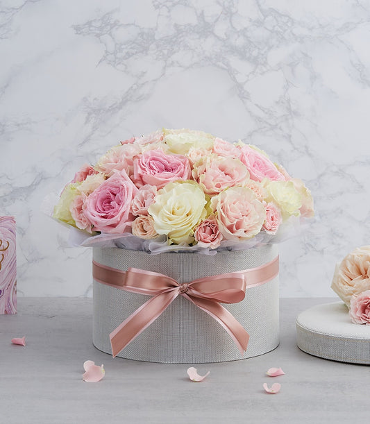 Pastel pink and cream roses in light grey hatbox with rose gold ribbon