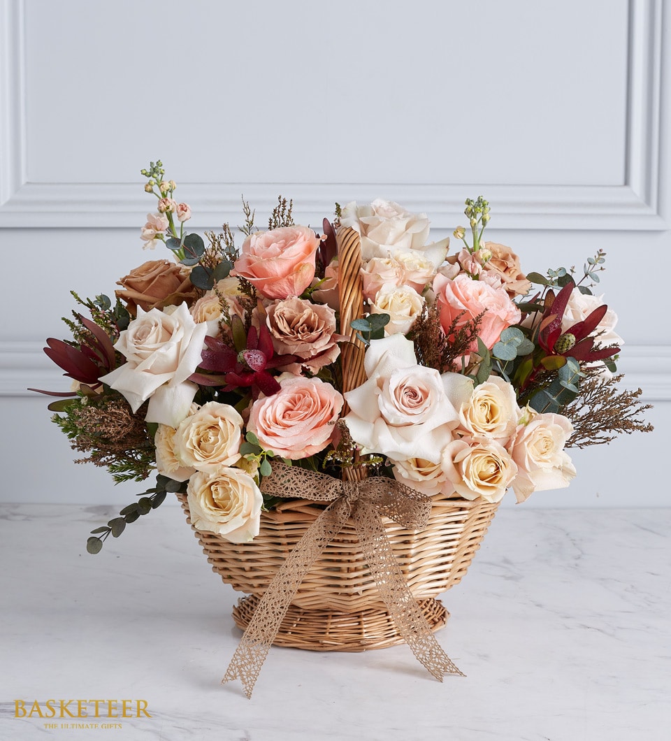 Timeless Elegance rose basket with peach, pink, and cream roses in woven wicker with ribbon bow