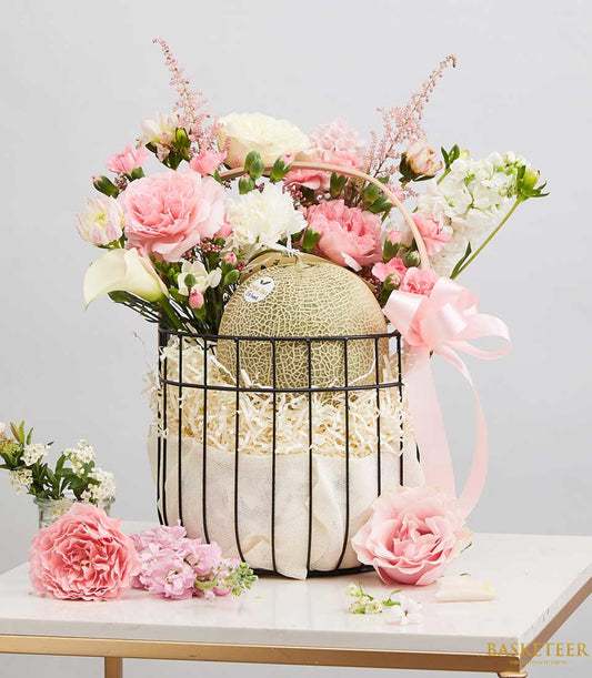 Vibrant melon and fresh flower basket with pink roses, white calla lilies, and cream carnations in black wire design