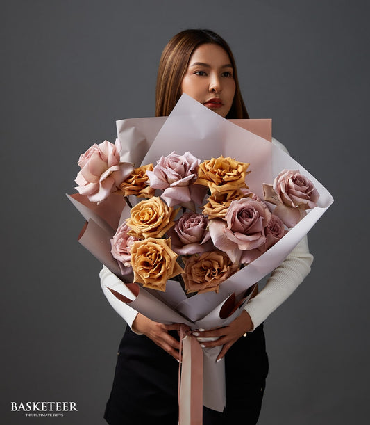 Muted rose, purple, and golden-brown rose bouquet with dusty earth tones and pink wrapping for anniversaries