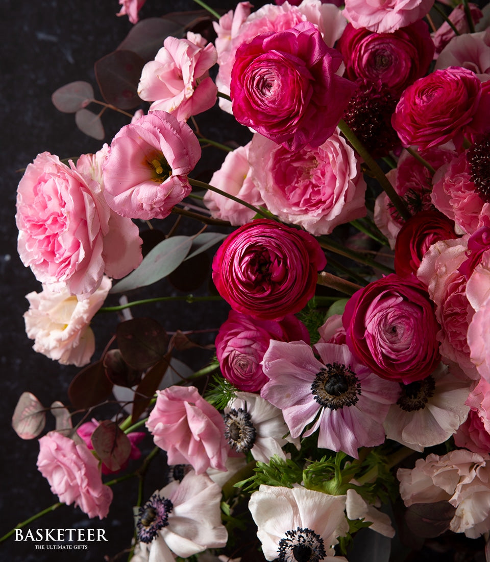 Pink and fuchsia fresh flower bouquet with ranunculus, garden roses, and anemones by Basketeer