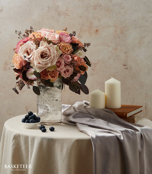 Peach and pink roses in clear glass vase with fresh flower arrangement for gifting