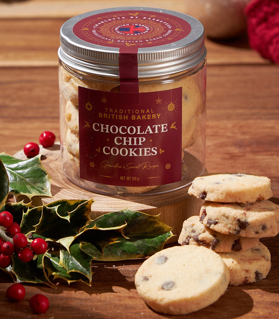 Traditional British chocolate chip cookies in gift jar with festive holly and red berries