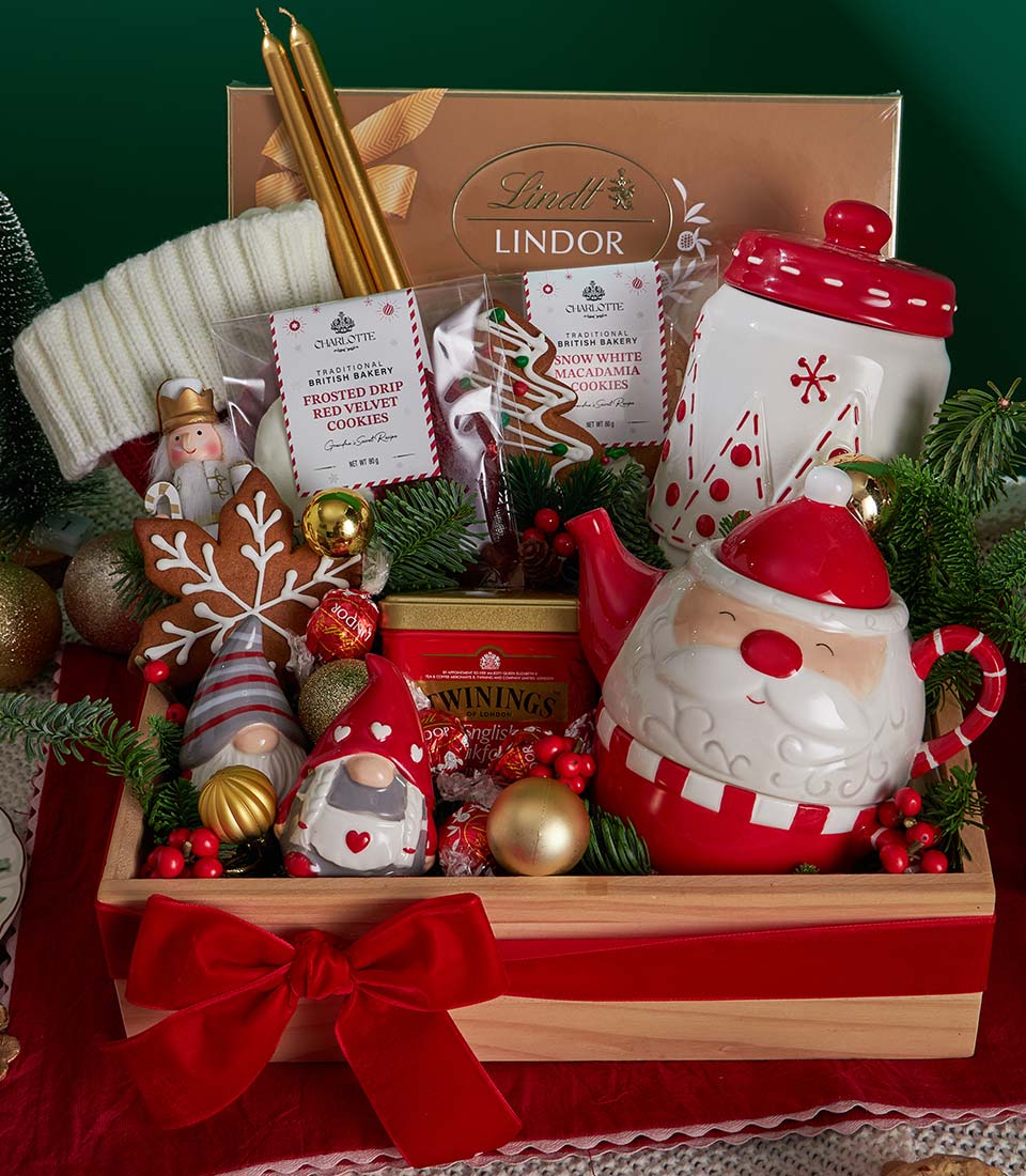 Festive Christmas gift crate with red velvet bow, Santa teapot, holiday cookies, Lindor chocolates and gold candles