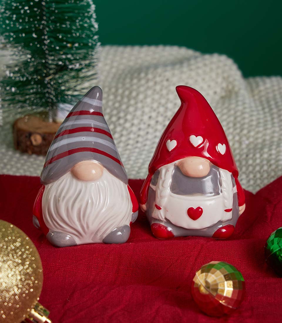 Ceramic Christmas gnomes with festive decorations on red fabric for holiday gift hampers