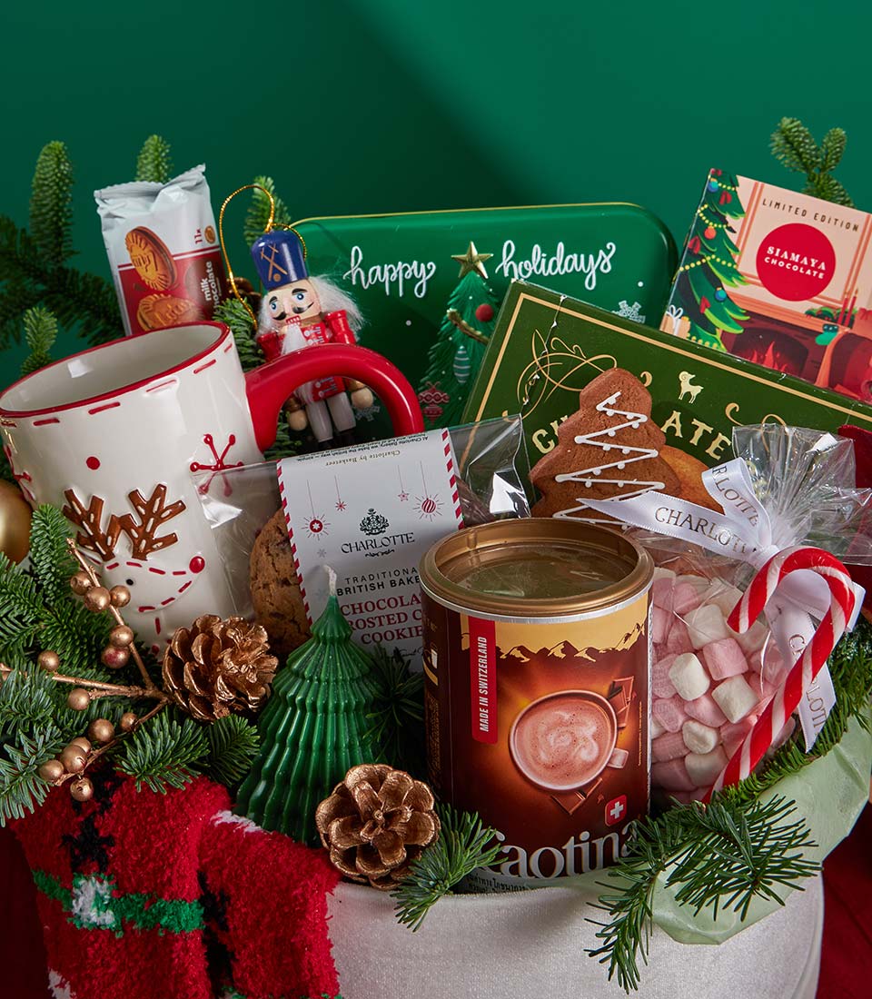 Festive Christmas gift basket with hot chocolate, gingerbread cookies, reindeer mug, and holiday treats