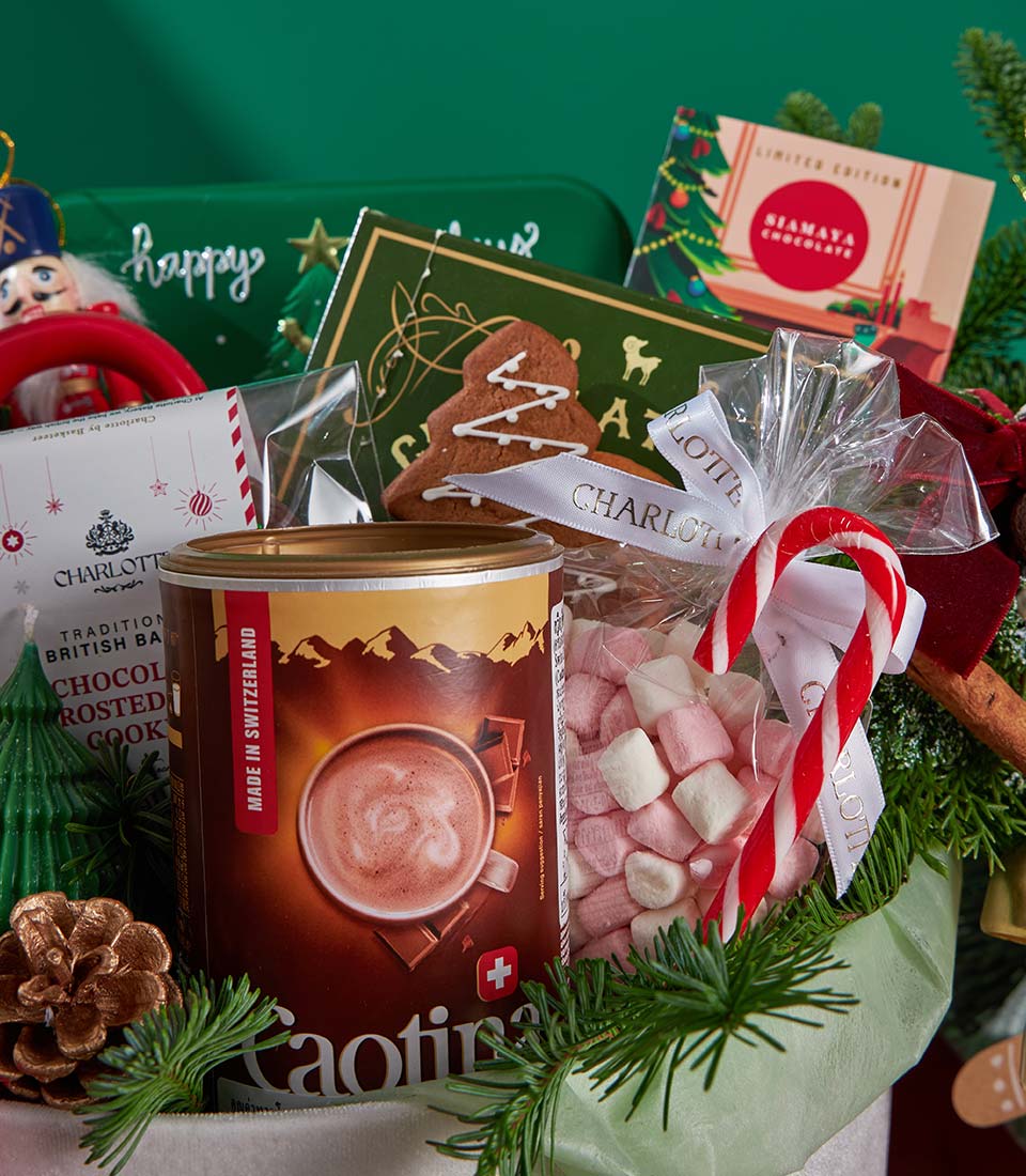 Festive Christmas gift basket with Swiss hot chocolate, marshmallows, gingerbread cookies, and holiday chocolates