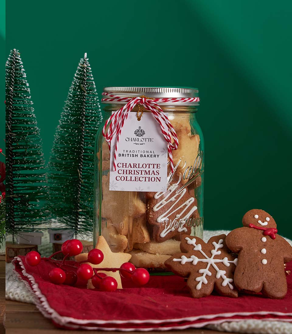 Festive Christmas cookies and hot chocolate gift basket with British bakery treats in glass jar, star and gingerbread