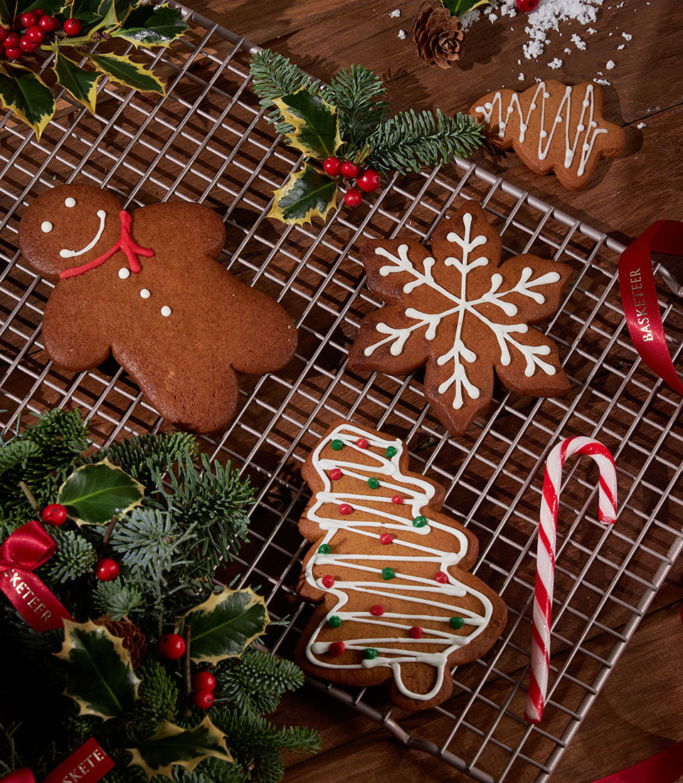 Charlotte Bakery gingerbread cookies: a homemade artisan selection with a gingerbread man, snowflake, and Christmas tree, decorated with white icing.