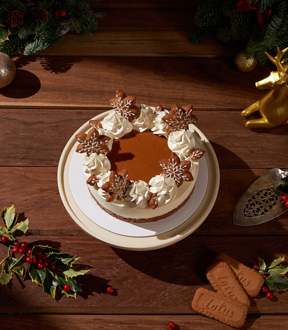 Charlotte Bakery Christmas cheesecake, an artisan cake order. Gingerbread snowflakes and cream cheese frosting decorate this custom cake in Bangkok.