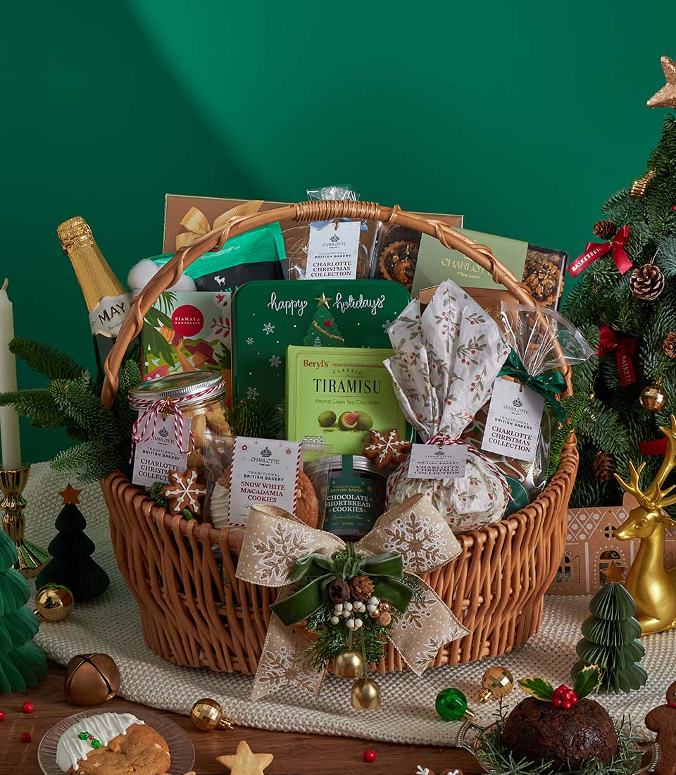 Luxury Christmas gourmet gift basket with sparkling wine, tiramisu, macadamia cookies, and festive ribbon in woven wicker