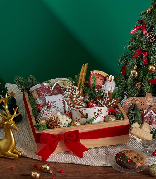 Wooden crate Christmas gift basket with British shortbread, gingerbread cookies, snowflake mug, and chocolate treats tied