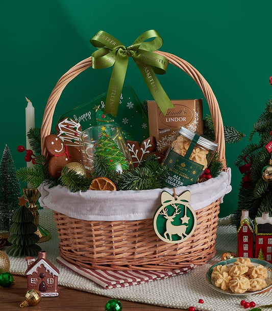 Festive wicker Christmas gift basket with Lindt chocolates, British butter cookies, gingerbread, and holiday decorations