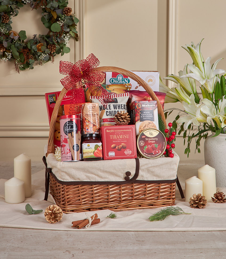 Festive red wicker gift basket with gourmet snacks, wafers, jam, and chocolate treats, tied with glittery red bow for New