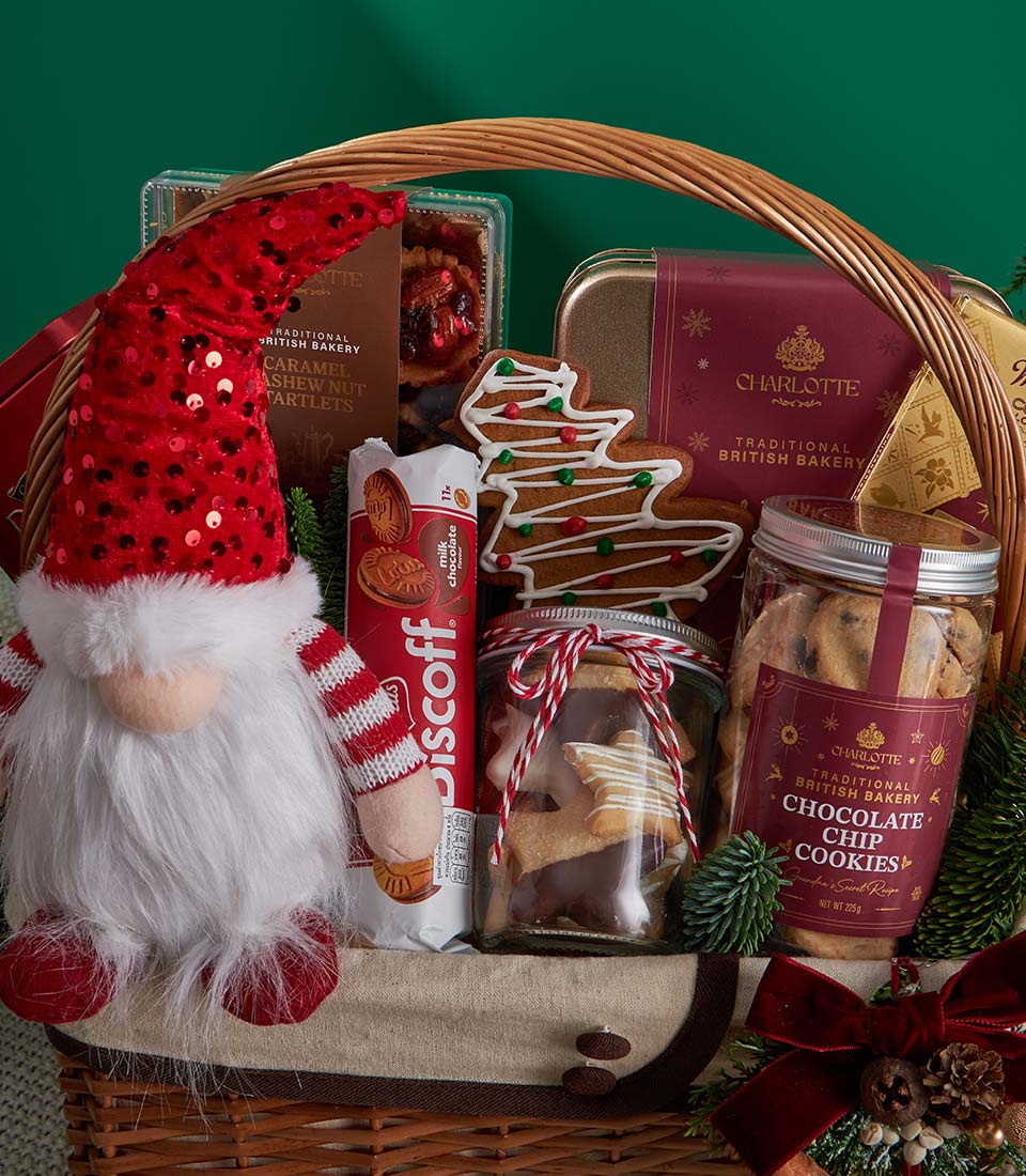 Festive Christmas gift basket with gingerbread cookies, chocolate biscuits, and holiday gnome in woven wicker