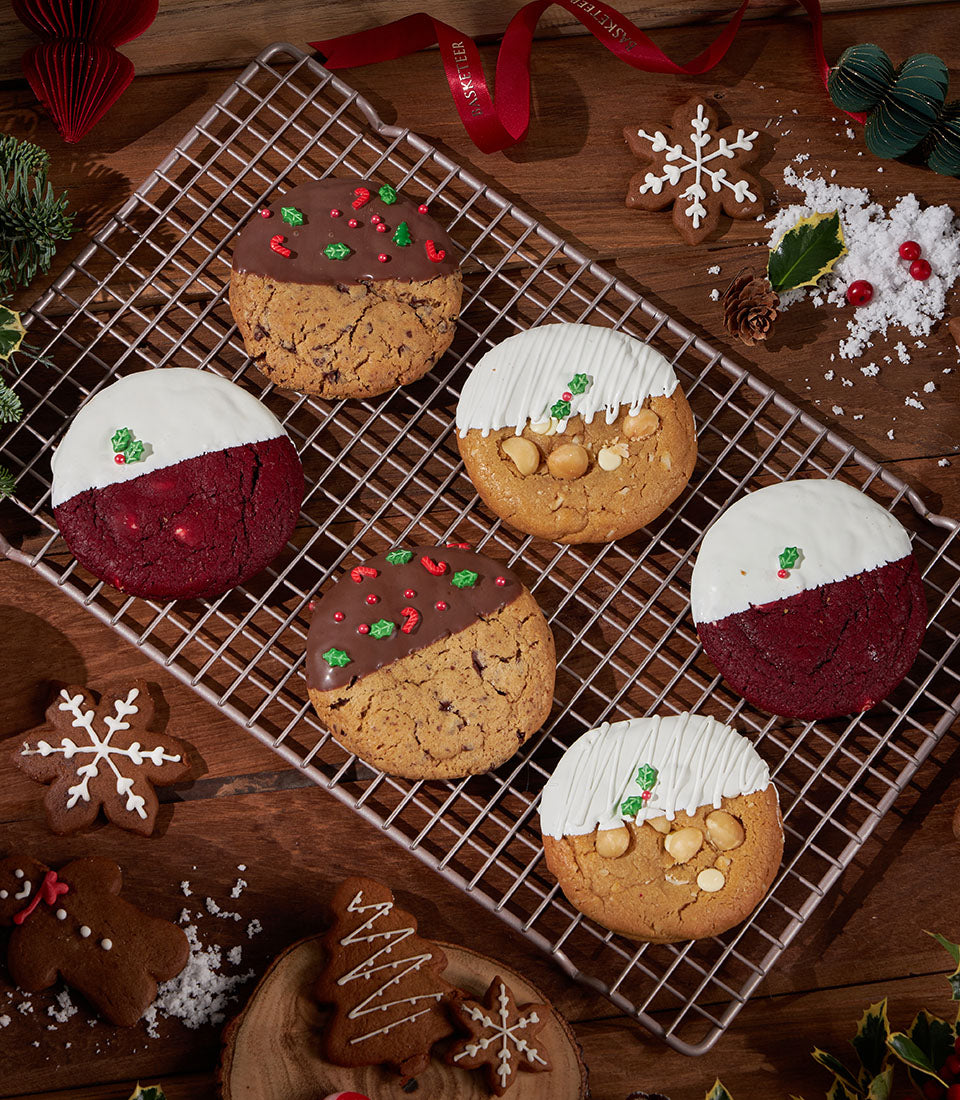 Festive assortment of soft-baked Christmas cookies with chocolate, velvet, and macadamia varieties on cooling rack