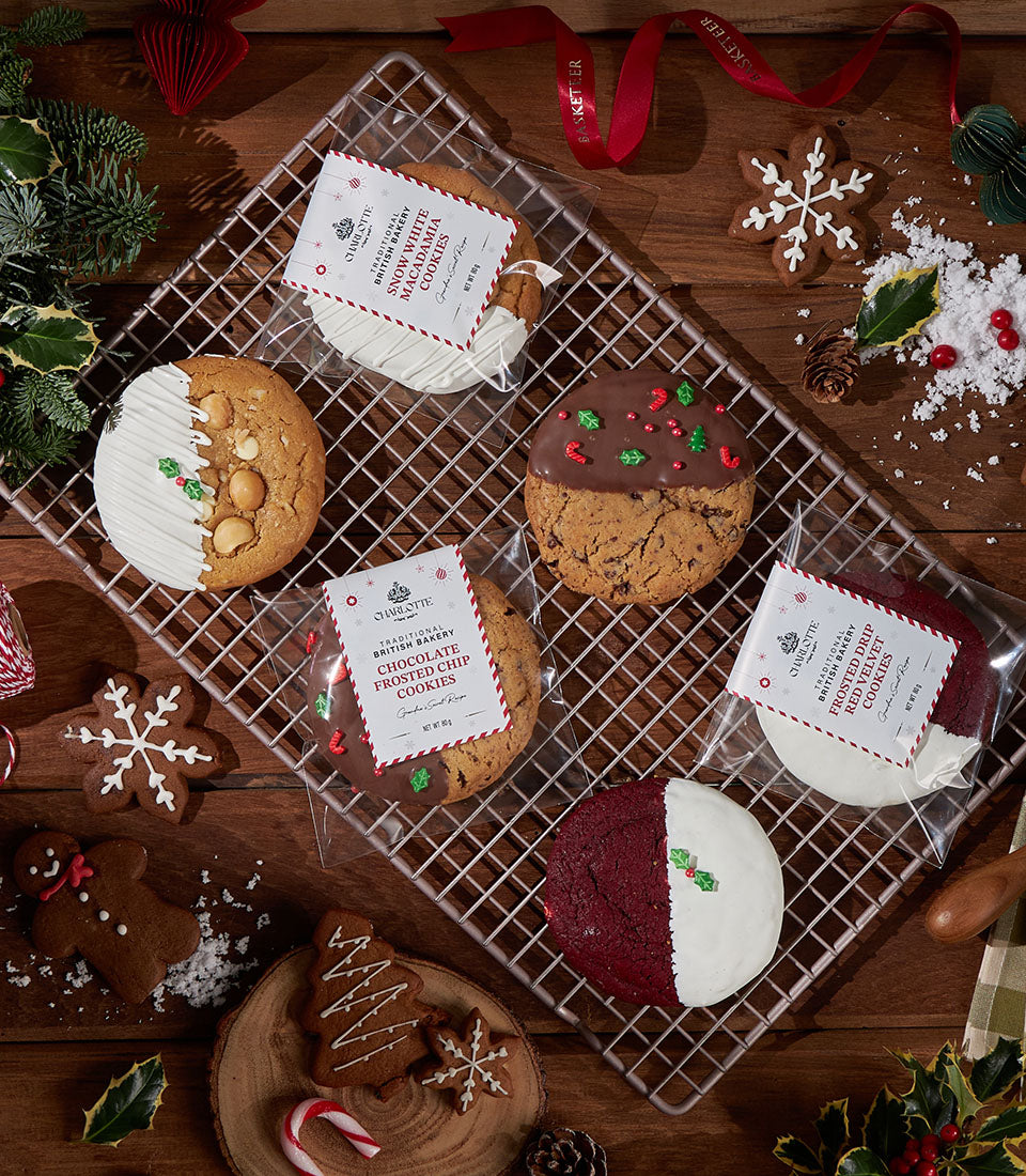Festive Christmas cookie collection with macadamia, chocolate chip, and red velvet varieties on wooden surface