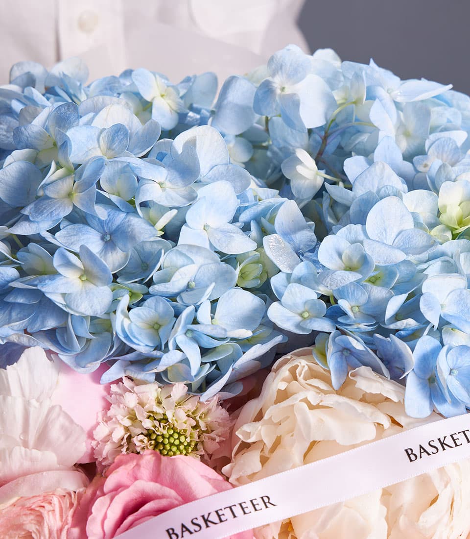 Pastel blue hydrangea and soft pink rose mixed bouquet with cream peony in luxury gift box