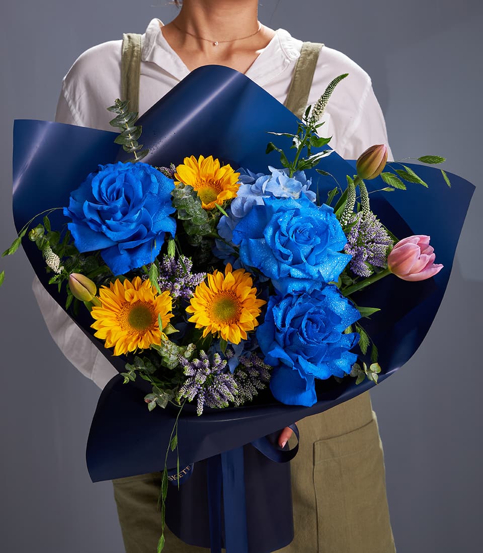 Royal blue roses and sunflowers bouquet with dark blue wrap and matching ribbon