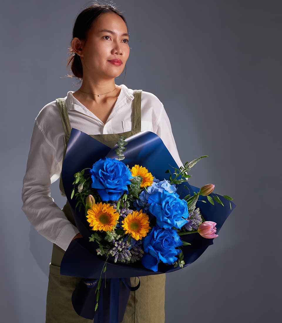 Vibrant blue rose and yellow sunflower bouquet with dark blue wrap, fresh luxury flowers for gifting