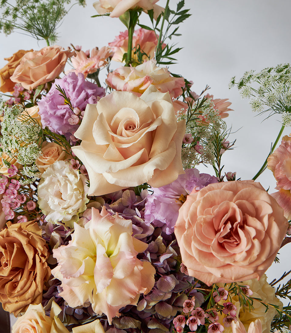 Caramel and blush roses with lilac flowers in premium arrangement, fresh floral gift basket