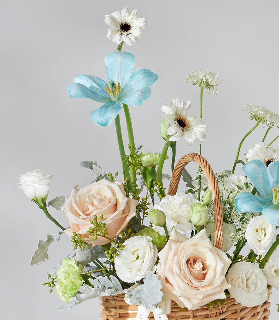 Blue Serenity wicker flower basket with tulips, roses, gerbera daisies, and lisianthus for birthdays