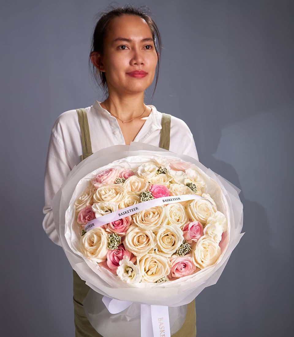 Eternal Charm mixed bouquet of cream and pink roses with white filler flowers, wrapped in white paper