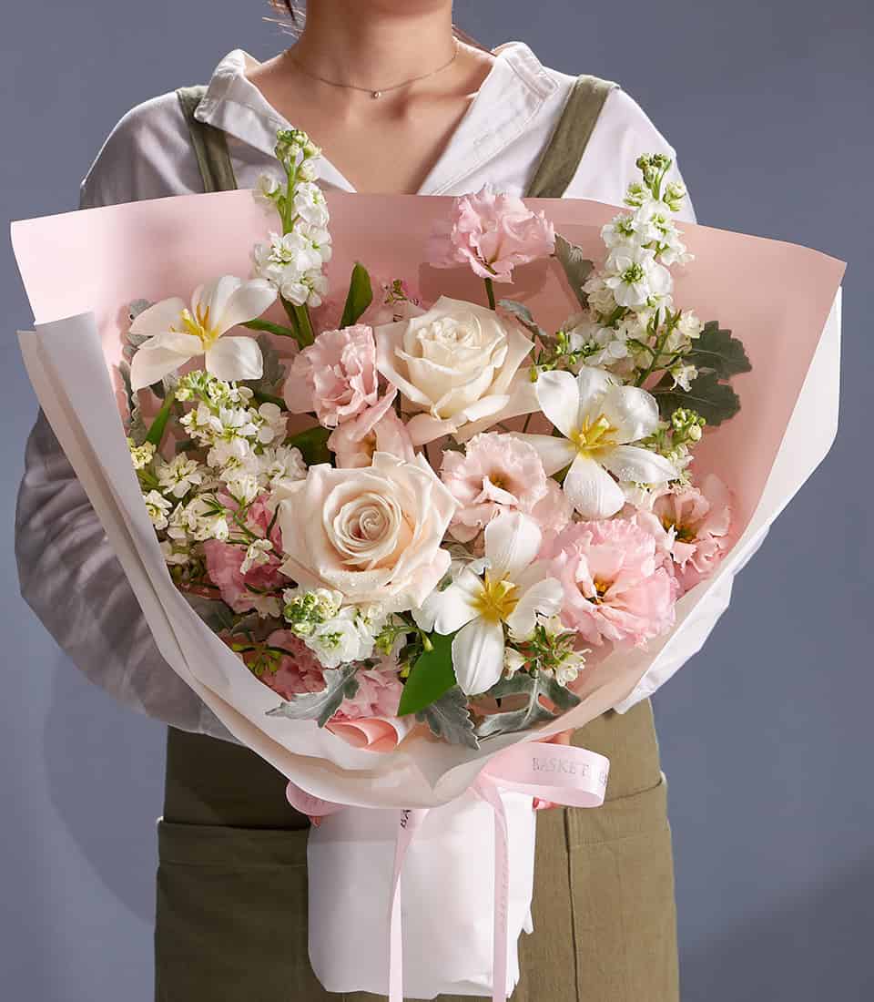 Ivory and blush rose bouquet with white freesia and pastel pink wrapping, fresh cut flowers for gifting