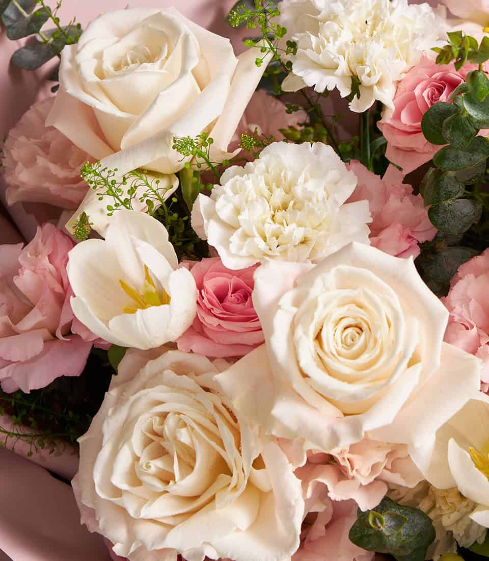 Ivory and blush rose bouquet with white tulips and cream carnations, soft pastel arrangement