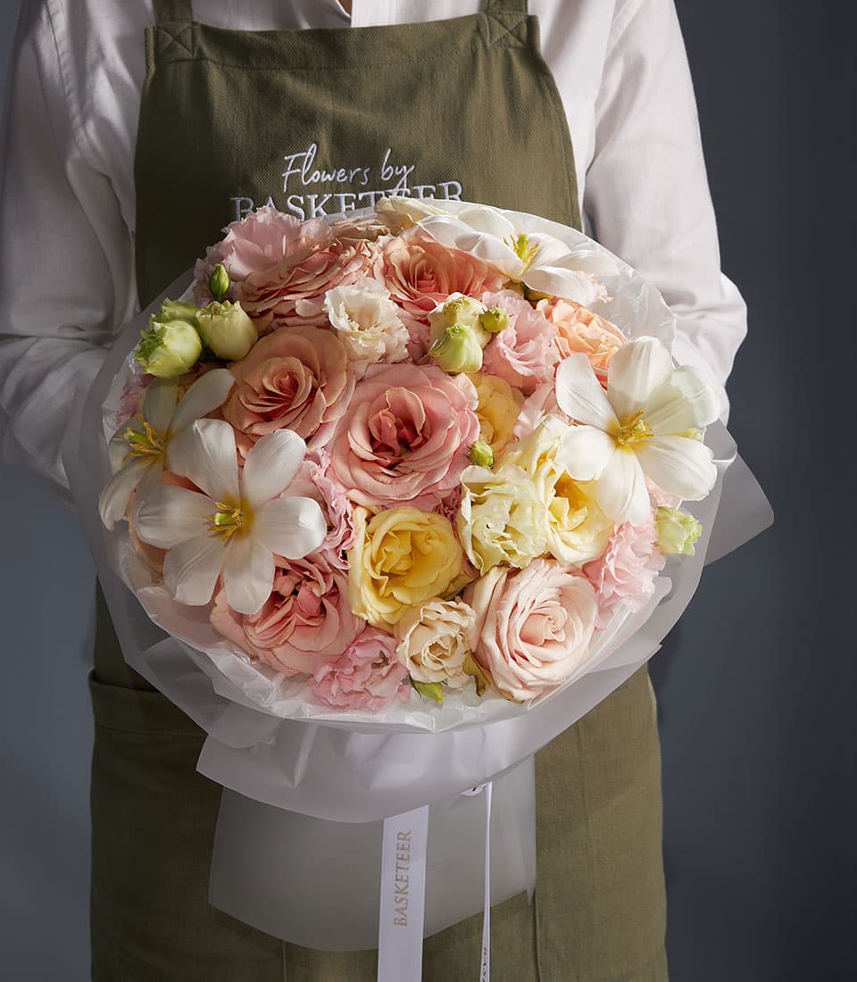 Premium fresh flower bouquet with roses, lisianthus, and tulips in pink, peach, yellow, and white