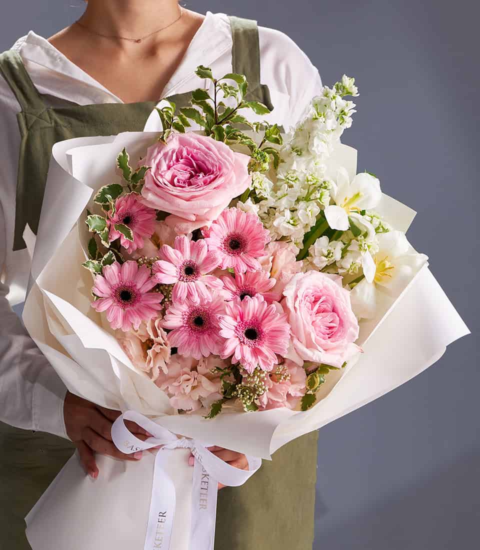 Pink gerberas, garden roses and white stock fresh flower bouquet with white ribbon wrap