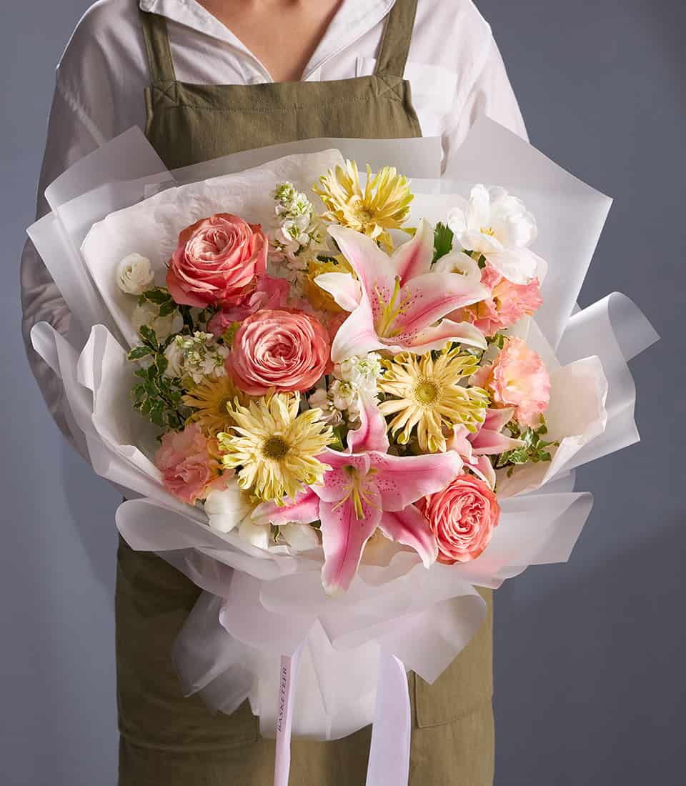 Pink lilies and peach roses champagne bouquet with white ribbon wrap, fresh luxury flowers for anniversary