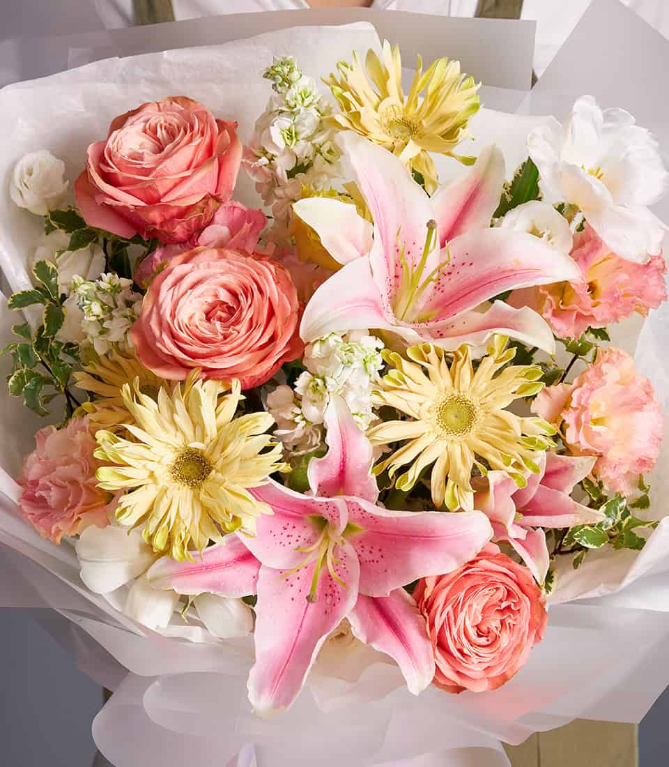 Pink lilies and peach roses champagne bouquet with gerbera daisies, wrapped in white tissue