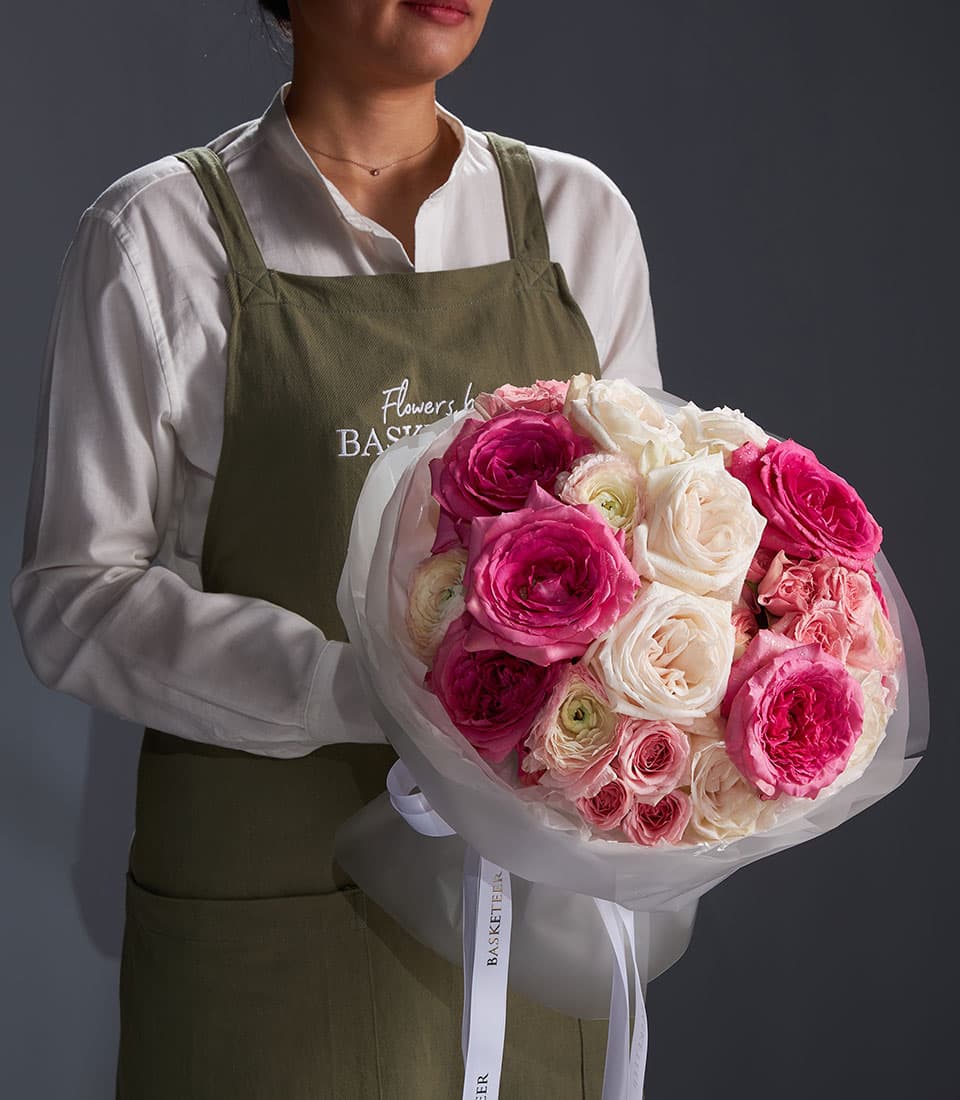 Blush Symphony mixed rose bouquet with cream and pink florals, wrapped in cellophane with white ribbon