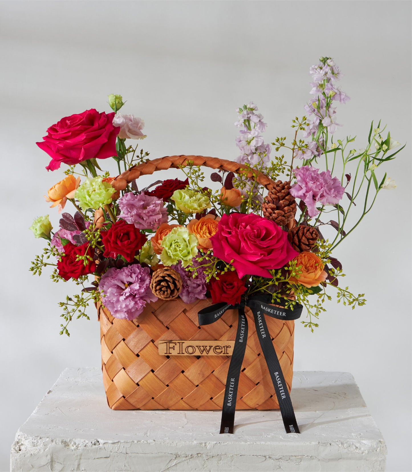 Crimson roses and garden flowers in woven wooden basket, premium birthday gift arrangement