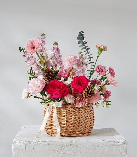 Crimson Charm wicker flower basket with fuchsia roses, pink gerberas, and stock flowers for birthdays